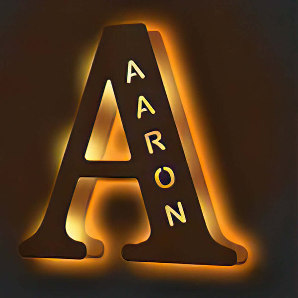 Enchanted Woodland Alphabet Lamp in the shape of the letter "A" with the name "Aaron" illuminated in a warm glow