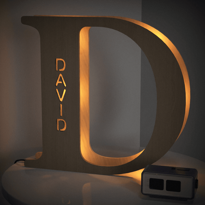 Wooden letter D alphabet lamp with David engraving, lighting up a room with a warm glow, perfect for personalized decor in bedrooms or nurseries.