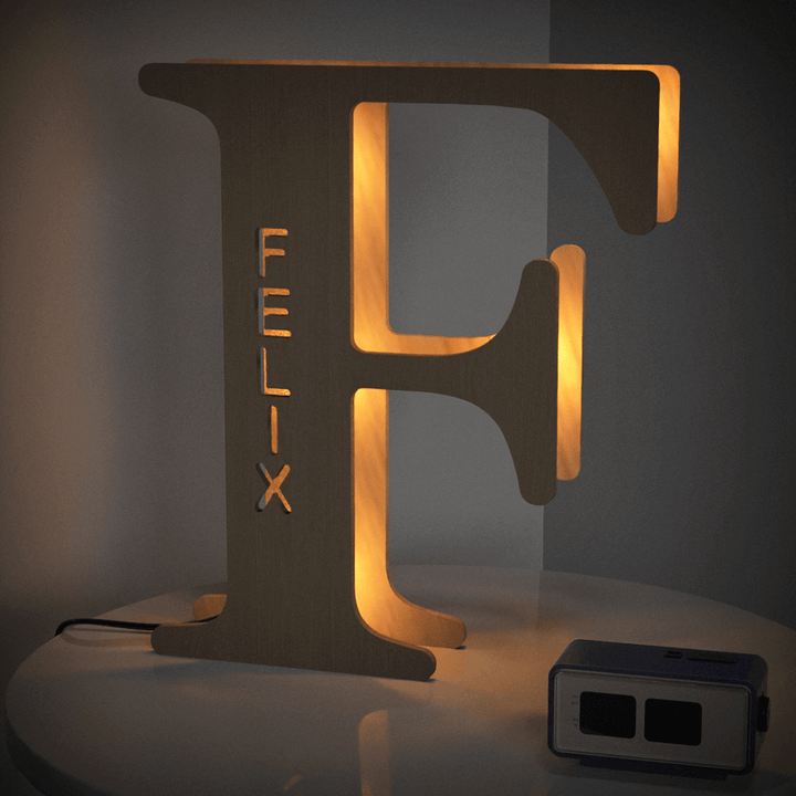 Wooden alphabet lamp shaped like the letter F with the name Felix illuminated, perfect for personalized decor in nurseries or bedrooms.