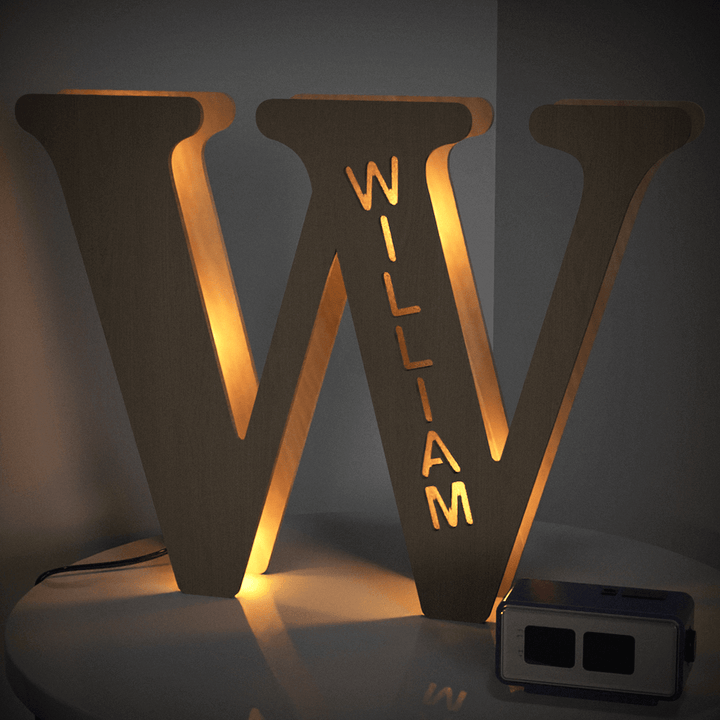 Enchanted Woodland Alphabet Lamp illuminated with the letter W spelling William, adding a warm glow to a cozy room setup.