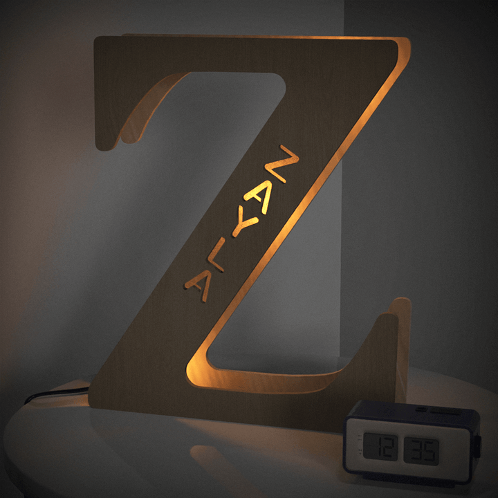 Wooden illuminated letter Z night light on bedside table with digital clock