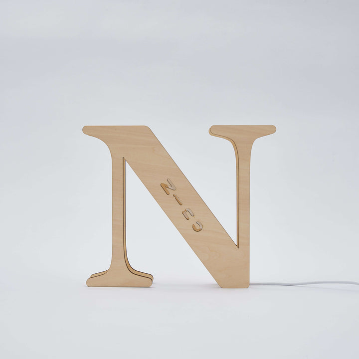 Wooden alphabet lamp letter "N" illuminated with a warm glow, perfect for adding a personalized touch to any room or nursery decor.